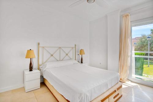 a white bedroom with a bed and a window at Luxury Apt, Beach, Pool open 365 days, Near Javea & Denia in El Verger