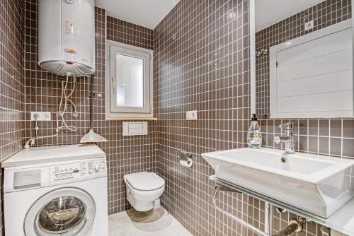 a bathroom with a washing machine and a sink at Luxury Apt, Beach, Pool open 365 days, Near Javea & Denia in El Verger