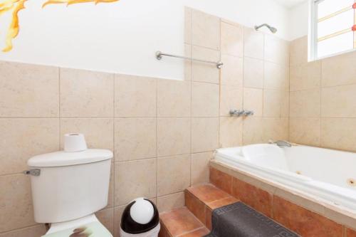 a bathroom with a toilet and a bath tub at HOSTAL DEL RÍO in Ibarra