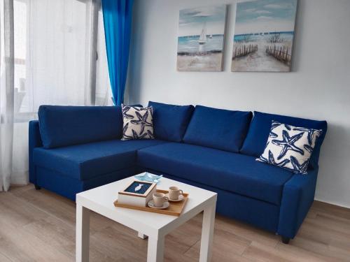 ein blaues Sofa im Wohnzimmer mit einem Tisch in der Unterkunft Blue Ocean in Costa Teguise