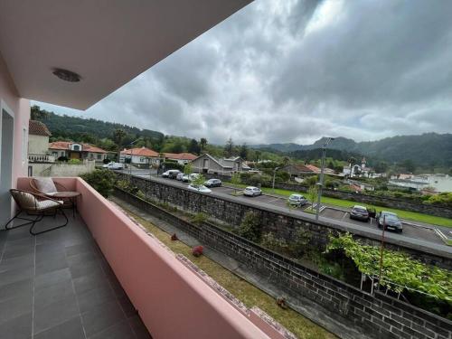 een balkon met uitzicht op een weg en auto's bij Natural Living Vacations in Furnas