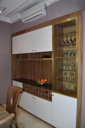 a kitchen with white cabinets and a bowl of fruit at Boulevard Court in Ejisu