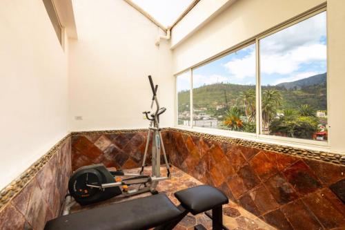a room with a gym with a bench and a window at HOSTAL DEL RÍO in Ibarra