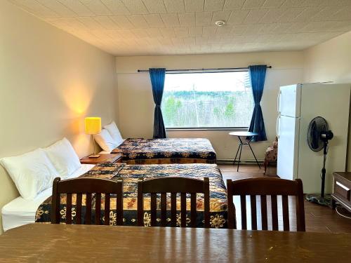 a room with two beds and a table and chairs at Lively Inn and Suites - Sudbury in Naughton