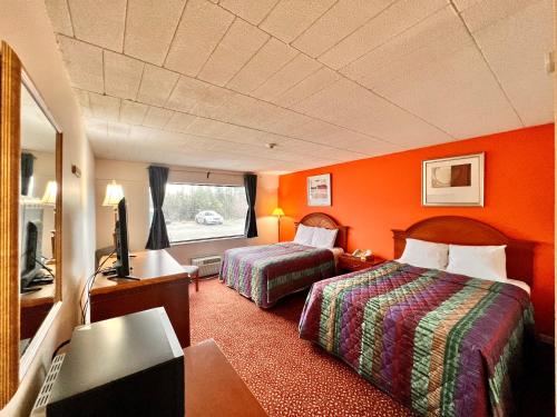 una camera d'albergo con due letti e una televisione di Lively Inn and Suites - Sudbury a Naughton