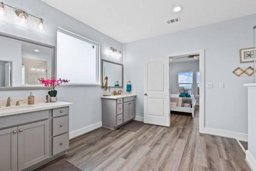 un baño con dos lavabos y dos espejos en Beachfront oasis! Hot tub, gameroom, double deck!!, en Bolivar Peninsula