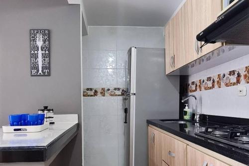 een keuken met een koelkast en een aanrecht bij 208 APARTAMENTO VACACIONAL AKUA RESORT® in Ricaurte