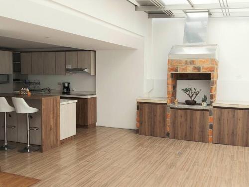 a large kitchen with wooden cabinets and a fireplace at Departamento nuevo, elegante y muy cómodo. in Loja