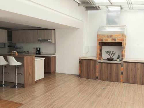 a large kitchen with wooden cabinets and a fireplace at Departamento amplio y cómodo en el centro de la ciudad in Loja