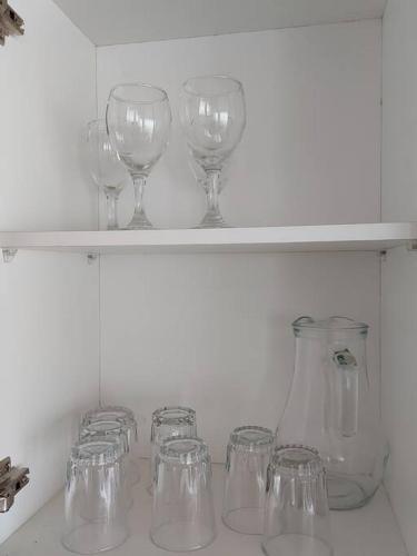 a row of wine glasses sitting on a shelf at Departamento amplio y cómodo en el centro de la ciudad in Loja