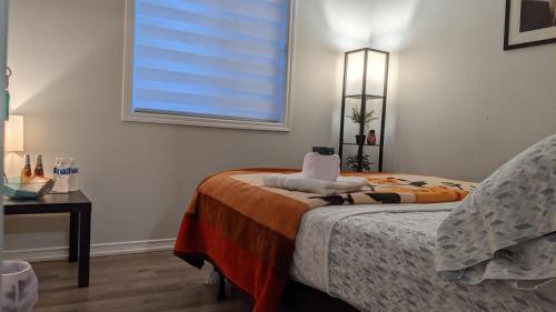 a bedroom with a bed and a window and a table at Brand New Big House in Niagara Region in Thorold