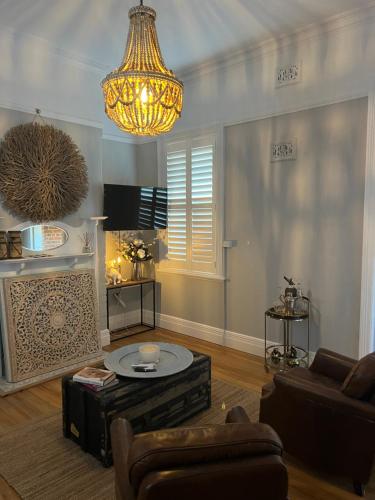 a living room with a couch and a chandelier at The Muddy Duck in Harden