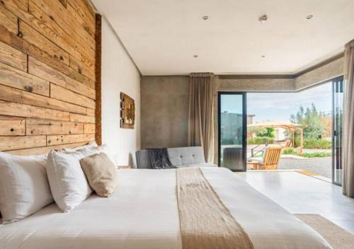 a bedroom with a large bed with a wooden wall at Chateaux del Valle Vacational Homes in Valle de Guadalupe