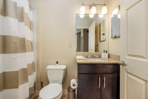 ein Badezimmer mit einem WC und einem Waschbecken mit einem Spiegel in der Unterkunft Lavish Living in DT Pittsburgh Valet Gym WiFi in Pittsburgh