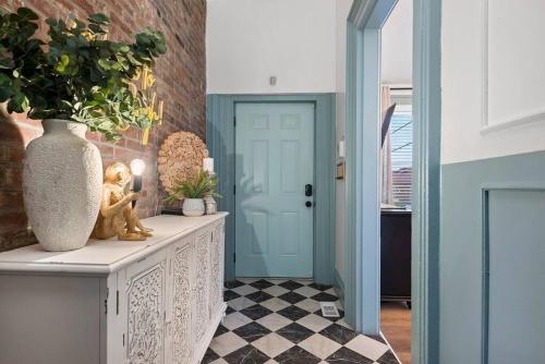 a hallway with a blue door and a vase at NEW! High-end Manchester Home w/ a hot tub in Pittsburgh