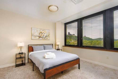 a bedroom with a large bed and large windows at Sprawling Stadium Views 24-7 Valet Gym WiFi in Pittsburgh
