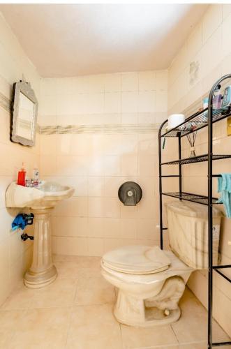 une salle de bains avec toilettes et lavabo dans l'établissement Casa Huitzilin, à Mexico