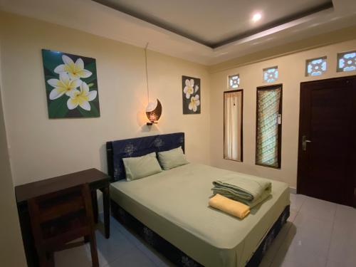 een slaapkamer met een bed met een lamp en een tafel bij D'ulun Carik Homestay in Tanah Lot