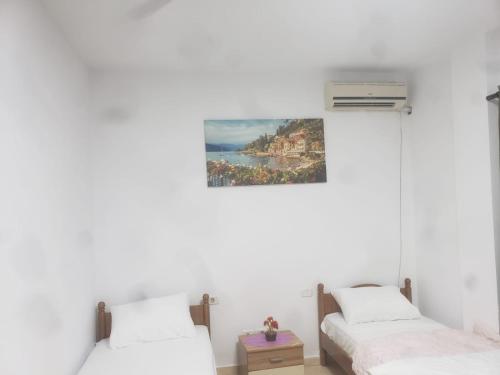 2 Betten in einem Zimmer mit einem Bild an der Wand in der Unterkunft Hostel Split Rock in Tirana