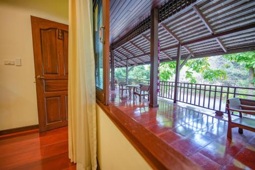 a room with tables and benches on a balcony at มนต์เมืองเชียงใหม่ รีสอร์ต Monmuang Chiangmai Resort in Hang Dong