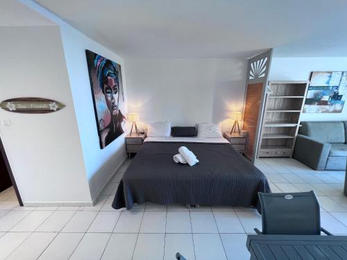 a bedroom with a bed and a chair in it at Studio Tortola Orient Bay VUE MER in Cul de Sac