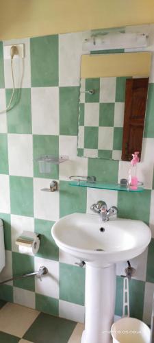 y baño con lavabo y espejo. en The Bliss Homestay en Gangtok