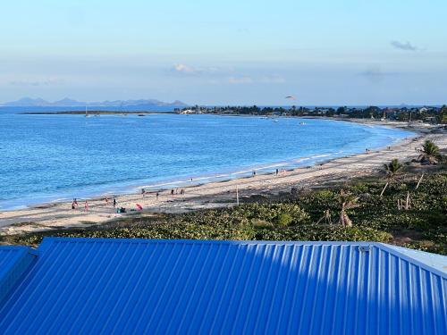 a beach with a blue wall and people on the beach at Studio Tortola Orient Bay VUE MER in Cul de Sac