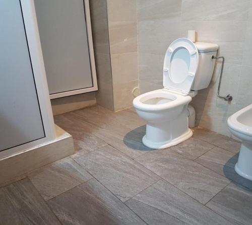 La salle de bains est pourvue de toilettes blanches et d'un lavabo. dans l'établissement Abokhalid, à Agadir