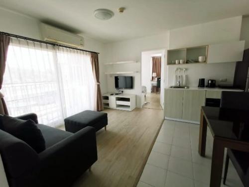 Luxury 2 bedrooms condo in Kho Takiab في هوا هين: غرفة معيشة مع أريكة وتلفزيون ومطبخ
