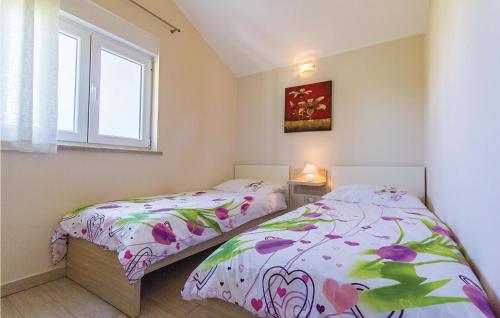 a bedroom with two beds and a window at Awesome Home In Pomer With House Sea View in Pomer