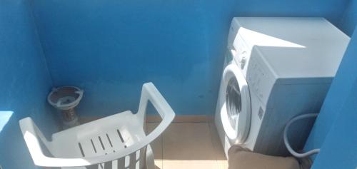 a white washing machine in a blue room at Bel appartement à 5min de la plage in Tangier