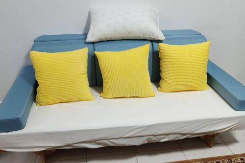 a bed with three yellow pillows on it at HMM Lili - Nilai in Nilai