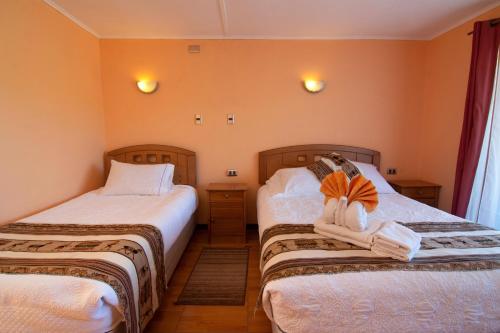 a bedroom with two beds with towels on them at Inti & Killa Hostal in San Pedro de Atacama