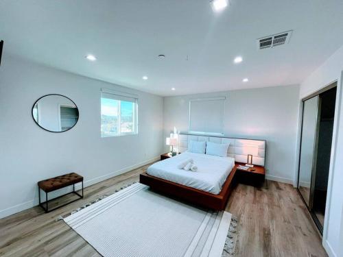 1 dormitorio con 1 cama grande y espejo en Stylish 4BR Townhouse in Mid City - CR2-C2 en Los Ángeles
