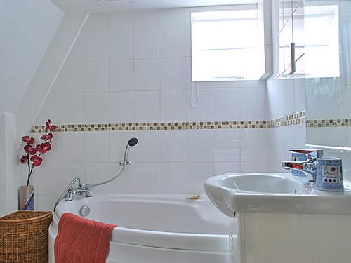 a white bathroom with a tub and a sink at Crown Cottage in Hartest