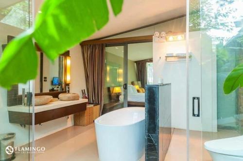 1 dormitorio y baño con bañera. en Hilltop Flamingo Đại Lải H230 Villa, en Hanói