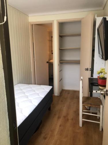 a small bedroom with a bed and a television at Habitación con baño privado in Santiago