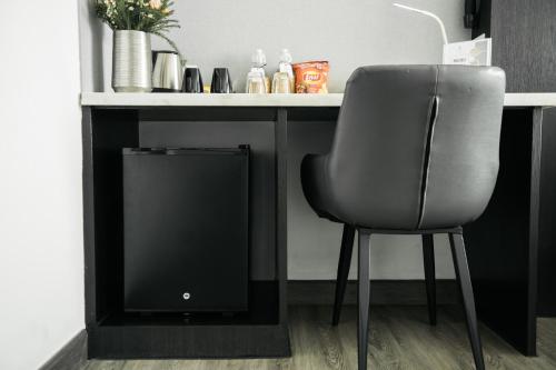 a chair sitting in front of a desk with a television at SureStay Hotel by Best Western Vientiane in Vientiane