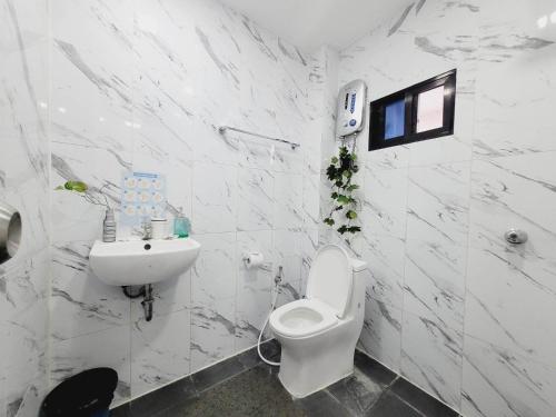 een witte badkamer met een toilet en een wastafel bij Gaja Go Dive & Inn in Moalboal