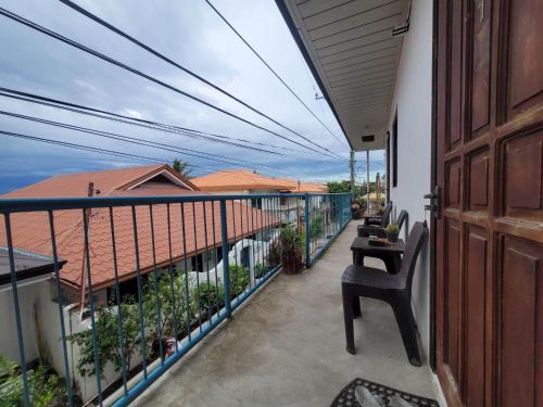 a balcony with a table and chairs on a building at Gaja Go Dive & Inn in Moalboal