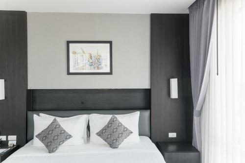 a bedroom with a bed with white sheets and pillows at SureStay Hotel by Best Western Vientiane in Vientiane