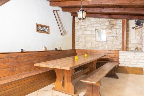 une salle à manger avec une table et des bancs en bois dans l'établissement Holiday house with a parking space Valtura, Pula - 16611, à Pula