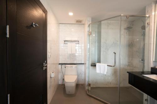 a bathroom with a toilet and a glass shower at SureStay Hotel by Best Western Vientiane in Vientiane