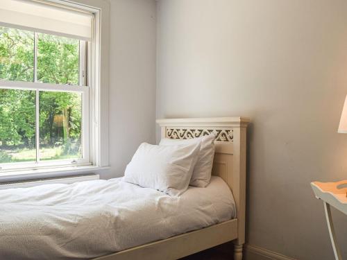 Dormitorio pequeño con cama y ventana en Forge Cottage, en Bradenham