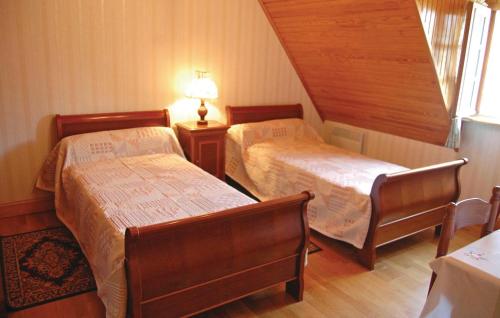 Cette chambre comprend deux lits, une lampe et une fenêtre. dans l'établissement Holiday Home Menez Rooz - 01, à Pont-lʼAbbé
