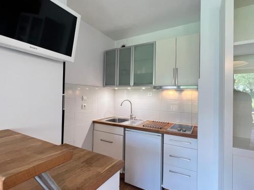 une cuisine avec des armoires blanches et un évier dans l'établissement Studio moderne et cosy 3*** avec balcon et wifi à Aix-les-Bains - FR-1-555-90, à Aix-les-Bains