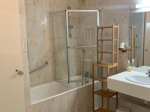 une salle de bain avec une douche, une baignoire et un lavabo dans l'établissement T2 bis dernier étage sécurisé avec balcon et mezzanine - FR-1-512-268, à Brides-les-Bains