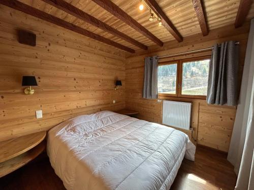 una camera da letto con letto in una camera in legno di Chalet La Clusaz, 5 pièces, 9 personnes - FR-1-437-103 a La Clusaz