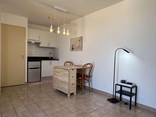 une cuisine avec une table et des chaises dans une pièce dans l'établissement Appartement studio proche port avec terrasse à Banyuls-sur-Mer - FR-1-225C-122, à Banyuls-sur-Mer