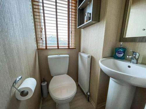 een kleine badkamer met een toilet en een wastafel bij Lovely Caravan With Decking Free Wifi At North Denes Caravan Park Ref 40145nd in Lowestoft